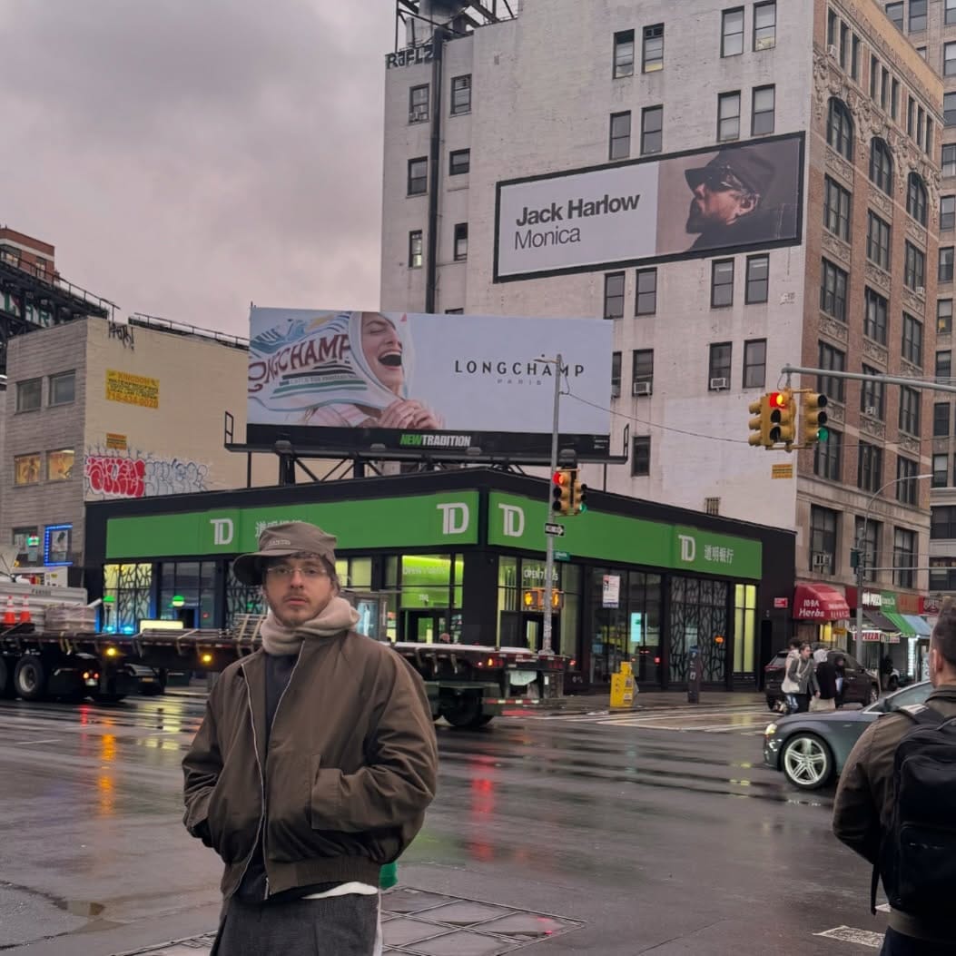 Jack Harlow рядом с рекламой своего альбома*